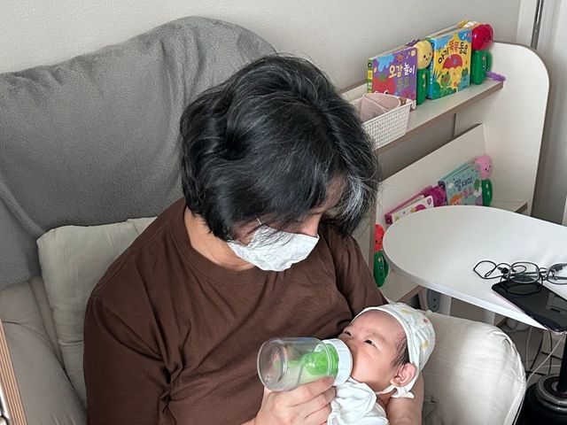 관리사가 아기를 안고 수유하는 모습