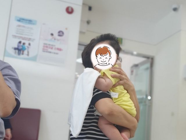 병원 대기실에서 관리사가 아기를 안고 있는 모습